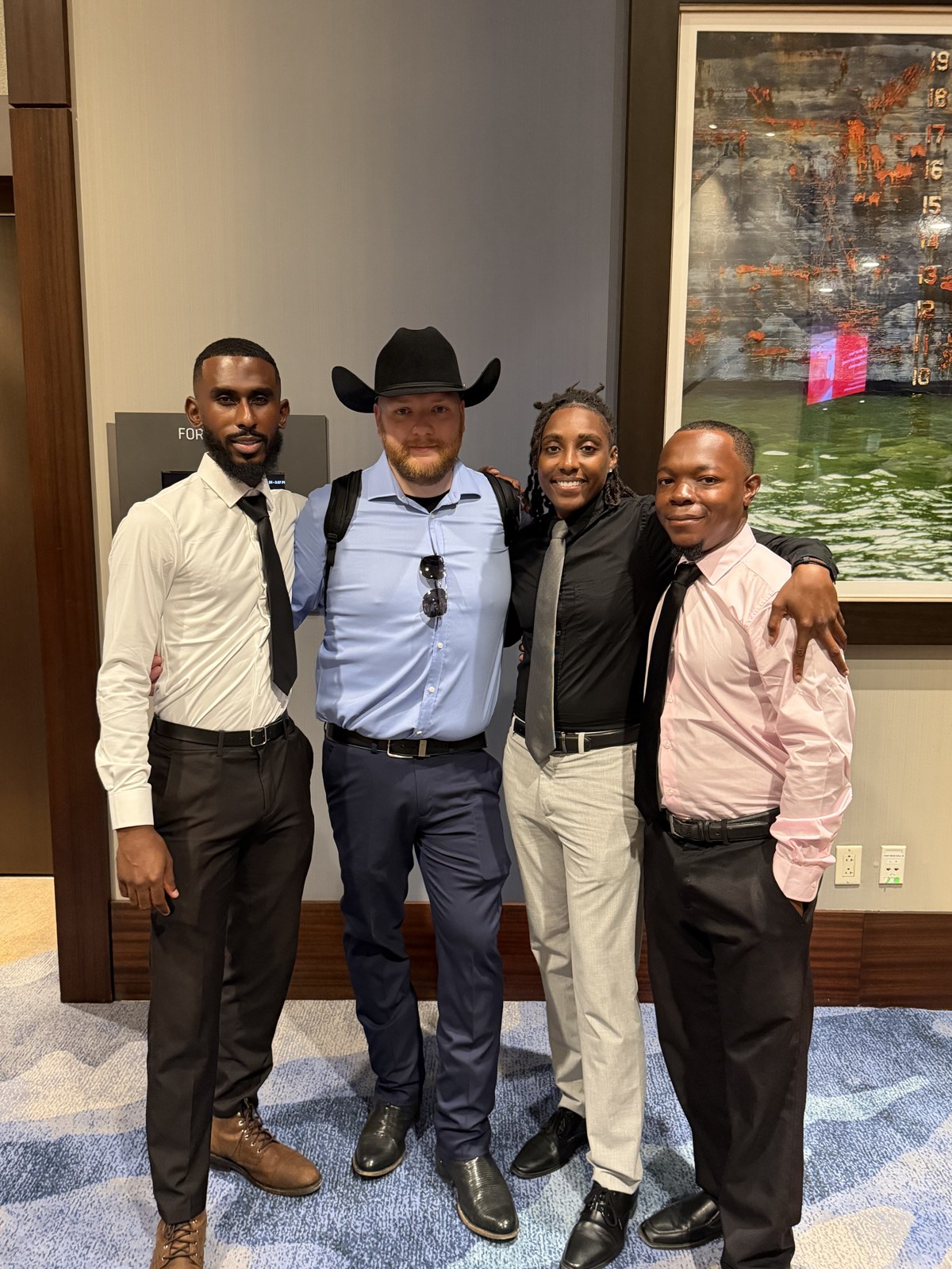 Four ScorpCo colleagues standing together at a professional event