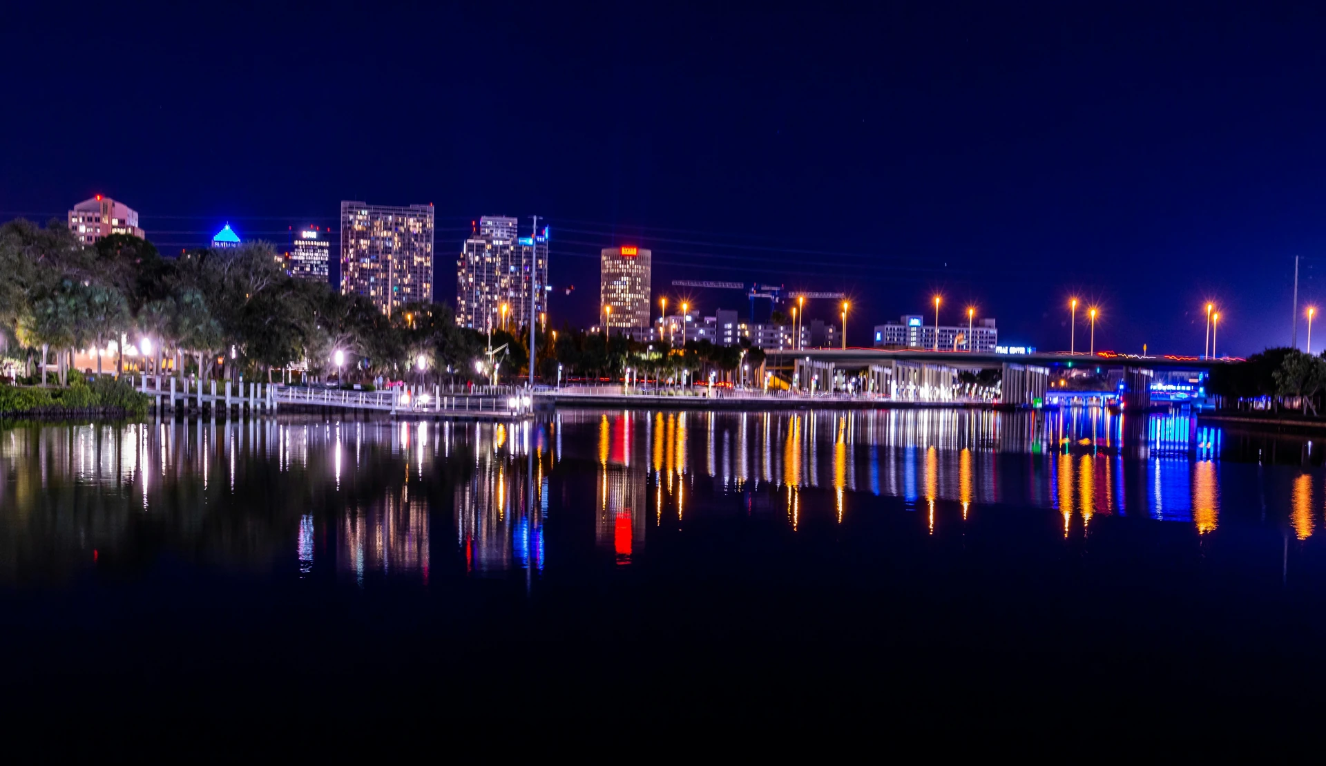 Tampa skyline and illuminated bridge reflected in the Hillsborough River at dusk